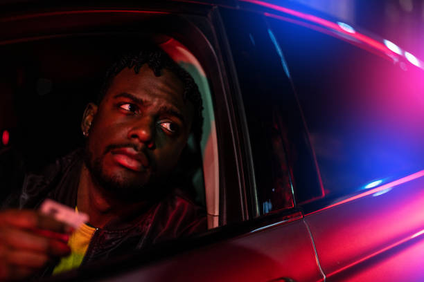 Police Traffic Stop An African American man being pulled over by the police at night. black crash stock pictures, royalty-free photos & images