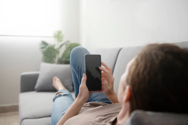 istock Woman Laying on Couch Mobile Phone at Home 1456981275