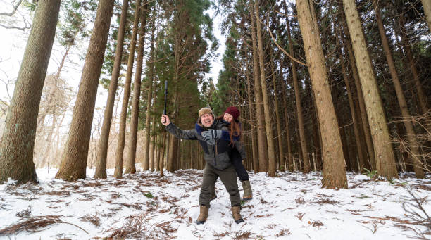 istock Fun couple in forest piggy back riding and vlogging with action camera 1456981683