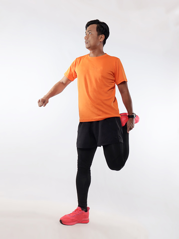 Asian male runner warming up prepararing his body before running workout. stretch his leg muscle, studio full length portrait against white background