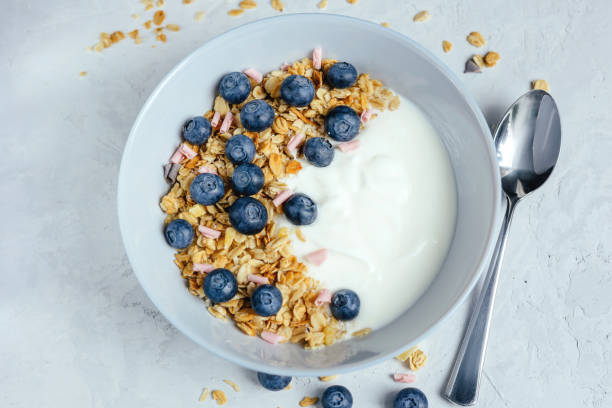 Yogurt with muesli and berries on a gray background.