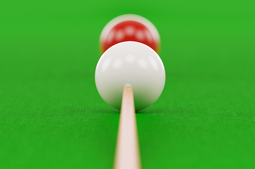 Snooker cue and pool balls over green pool table. Front view. Horizontal composition with copy space. Snooker concept.