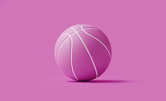 Pink basketball ball on pink background. Horizontal composition with copy space. Women's basketball concept.
