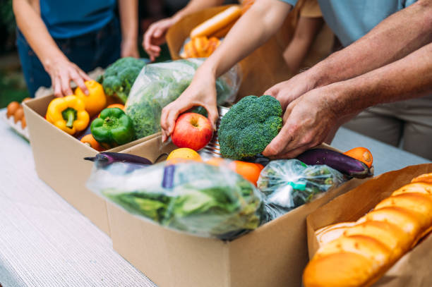 istock Unrecognizable food bank volunteers unpack donation box 1456995003