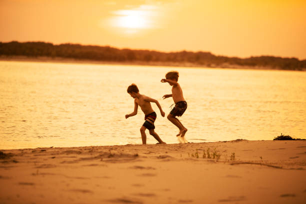 istock Brothers playing at the beach at sunset 1456995378