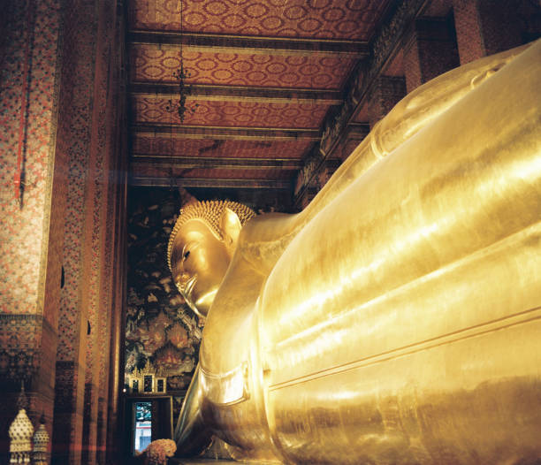 golden buddha statue on blue background, closeup of photo