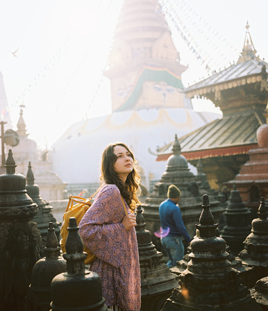 Young Caucasian woman standing on the background of Buddha stupa in Kathmandu