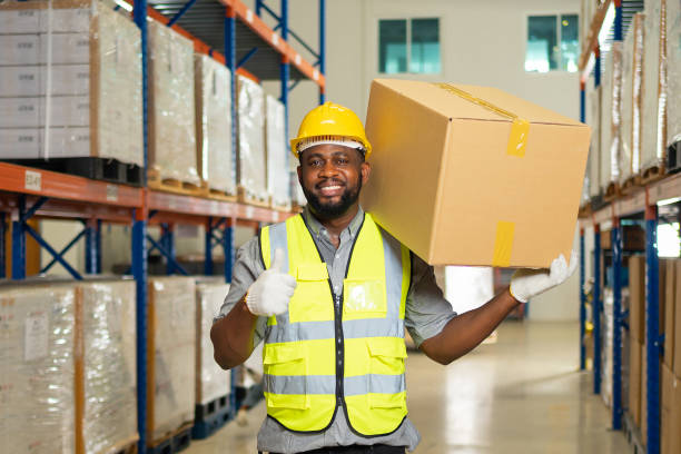 Portrait of black man worker working in large warehouse retail store industry factory. Rack of stock storage. Cargo in ecommerce and logistic concept. Depot. People lifestyle. Shipment service. stock photo