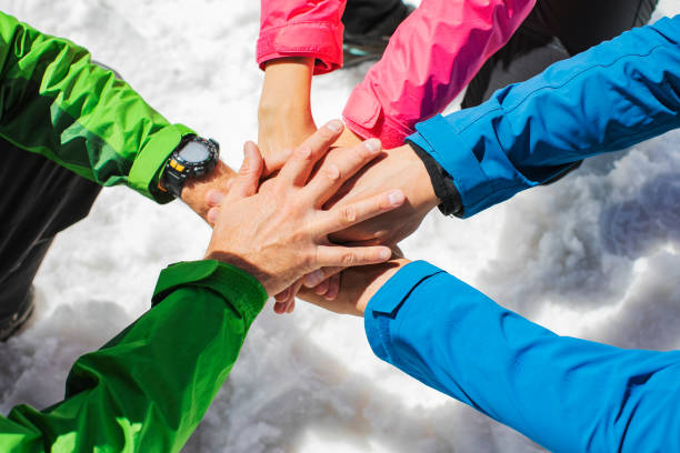 People hands together with snow at background