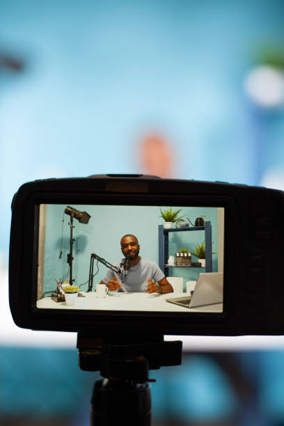 istock Vertical closeup of professional digital camera on tripod recording content creator talking 1457004734