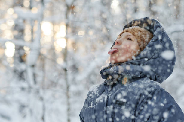 istock Girl having fun during snowing 1457005120