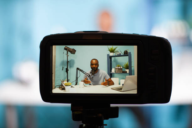 istock Selective focus on back screen of dslr filming influencer sitting at desk talking at professional microphone 1457005178