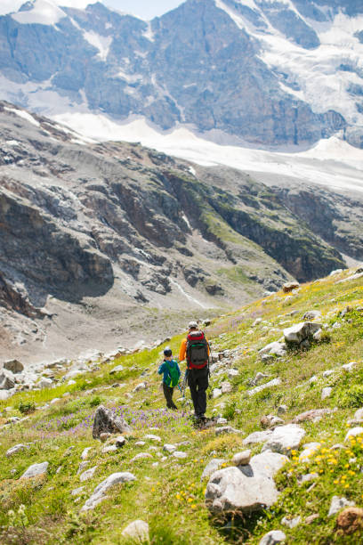 istock Father and son hiking in mountains together 1457010784