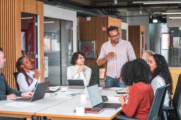 istock Employees Clap and Cheer for New Manager at Open Concept Office 1457011397