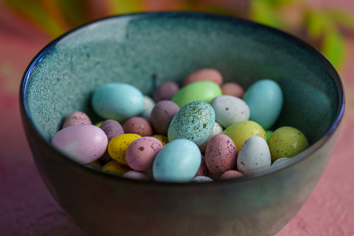 Speckled easter eggs in a ceramic bowl on a concrete surface