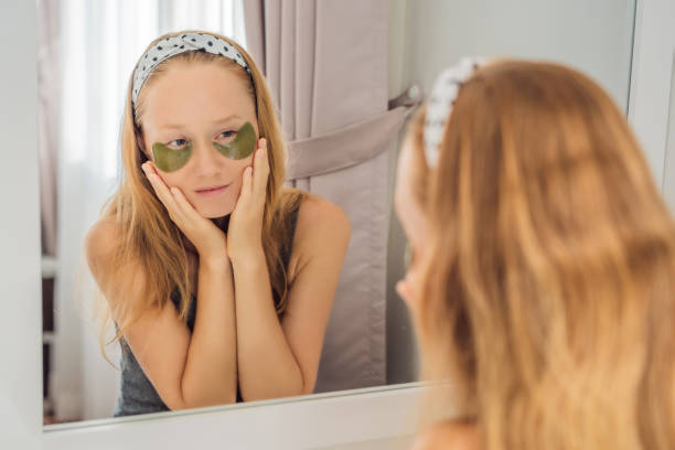 istock Mirror reflection smiling woman applying hydrogel eye care patches, moisturizing skin under eyes, enjoying skincare procedures 1457017732