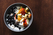 Healthy fruit and yogurt breakfast bowl on a wooden surface