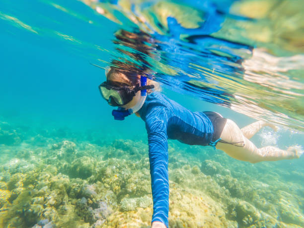 Young women at snorkeling in the tropical water stock photo