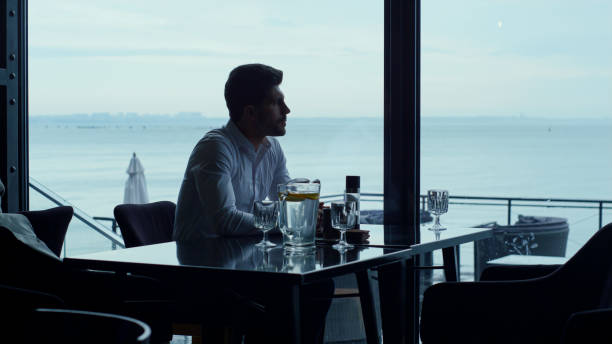 istock Stressed businessman spending breakfast in panoramic cafe. Loneliness concept 1457019884