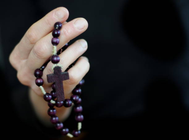 istock man praying to god with hands together with grey black background 1457021731