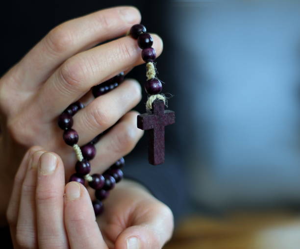 istock man praying to god with hands together with grey black background 1457021760