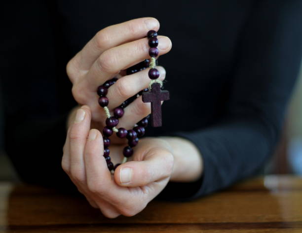 istock man praying to god with hands together with grey black background 1457021820