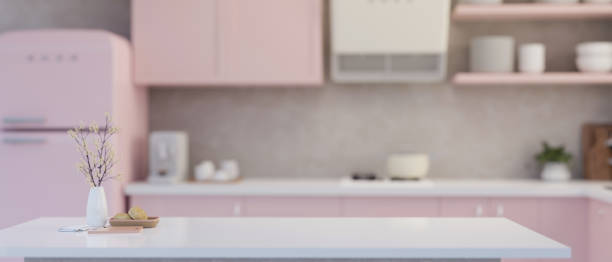 istock Modern white kitchen tabletop with flower vase and copy space over blurred pastel pink kitchen 1457029952