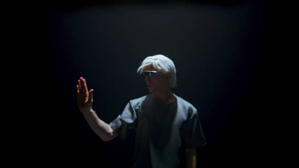 istock Man using vr glasses touching space in dark room. Focused cyber player swiping 1457035156