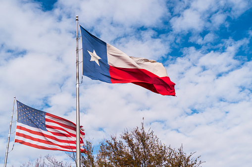 America Flag and Texas State Flag waving in the wind over Midland, Texas