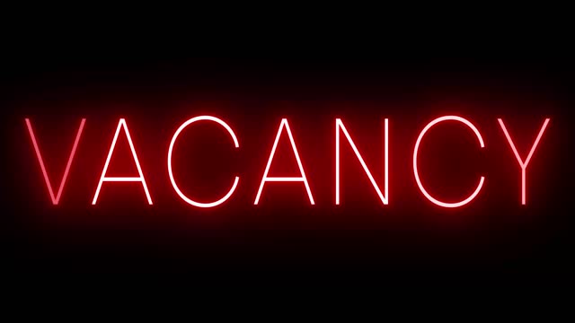 Red vacancy sign in neon against a black background