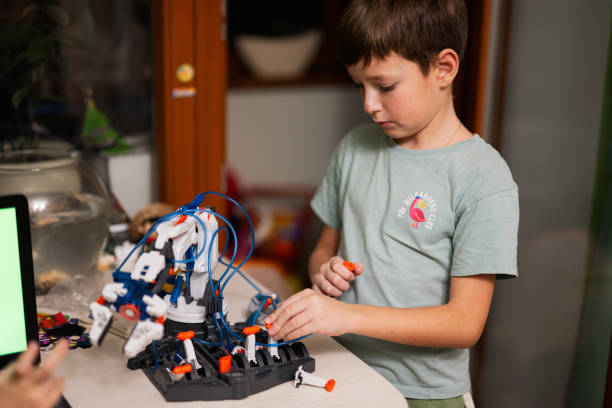istock Children learning repairing getting lesson control robot arm, robotic machine arm in home workshop, technology future science education. 1457043262