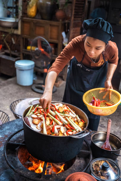 istock young vietnamese female chef cooking on open fire in restaurant 1457043804