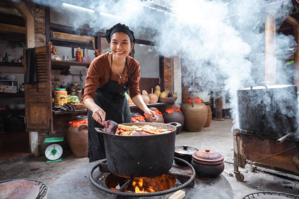 istock young smiling vietnamese female chef cooking on open fire in restaurant 1457045503