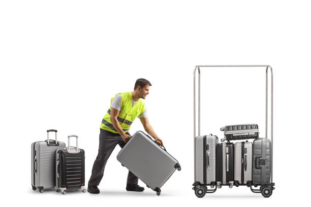 istock Male worker putting suitcases on a luggage trolley 1457046409