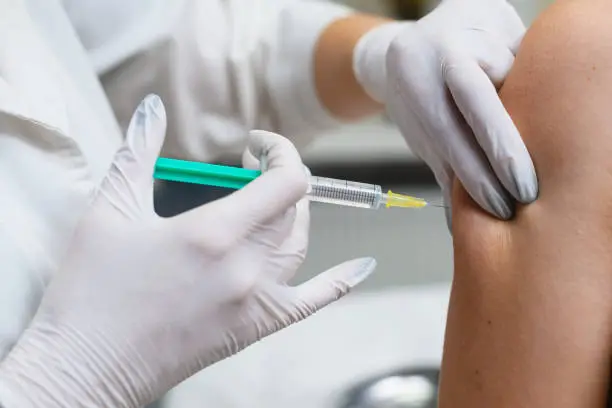 Doctor apply syringe needle in female hand, health vaccination and medical treatment concept