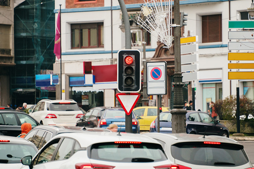 a city crossing with a semaphore, red light in semaphore, traffic control and regulation concept