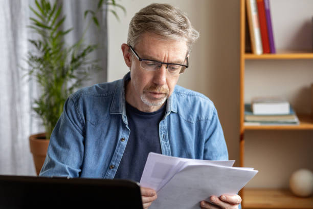 istock White 50 year old businessman working with paperwork at home office 1457049571