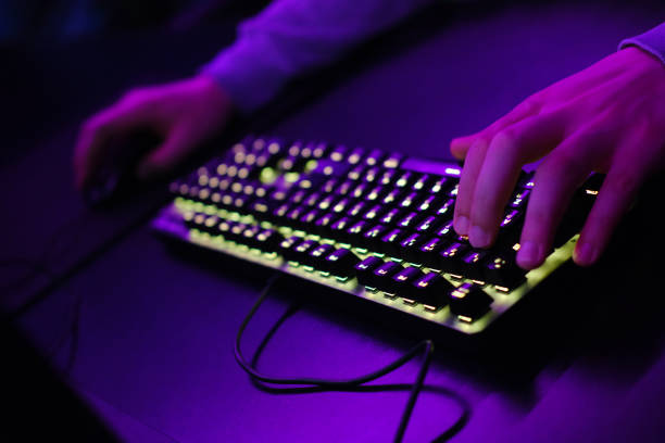 istock Close-up of a hand on a keyboard in neon color. Selective focus 1457050384