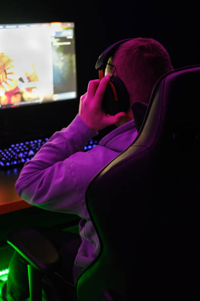 istock Young man putting on headphones for playing online 1457050520