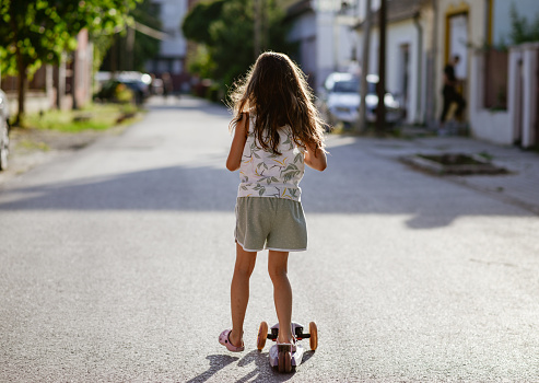 Beautiful girl having fun on a push scooter.