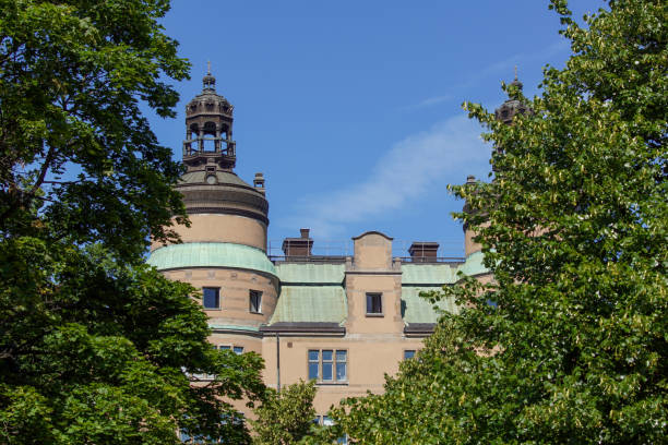istock Low angle view of trees and building against sky 1457057139