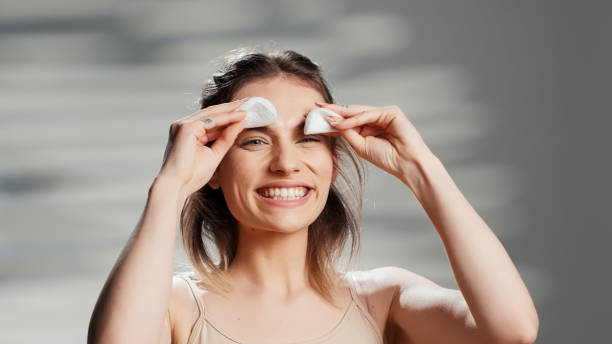istock Cheerful beauty model playing with cotton pads on camera 1457057214