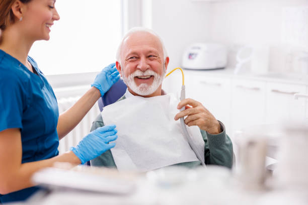 istock Senior man holding saliva ejector while at dentist office 1457057670
