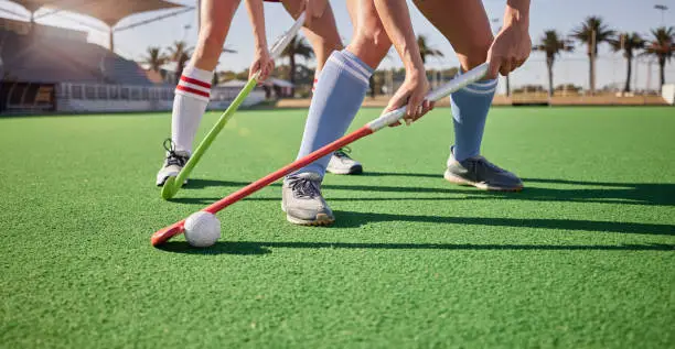 Sport, hockey and athlete legs on field playing game and fitness people workout, competition and exercise outdoor. Sports match, hockey player competitive and active life with training at stadium.
