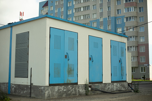 Electric unit on street. Technical construction for electrical support of building. Blue current booth. High voltage inside building.