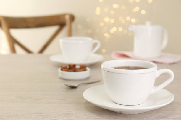 istock Cup of aromatic coffee on white wooden table indoors, space for text. Bokeh effect 1457058550