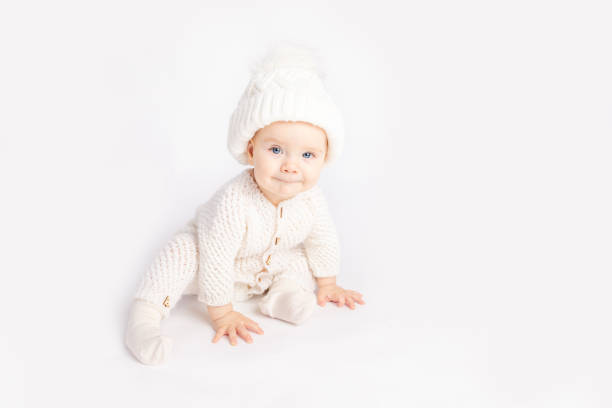 istock baby crawls in a warm suit and hat on a white isolated background, space for text 1457060372