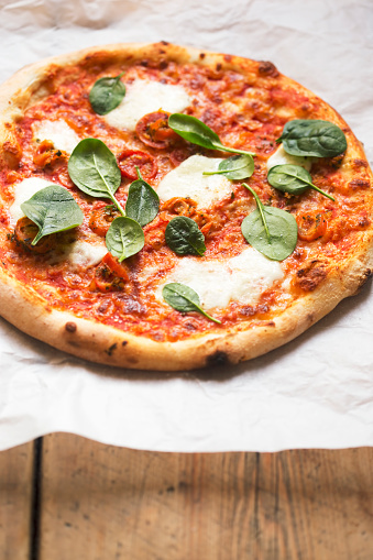 Pizza with tomato sauce, mozzarella and spinach