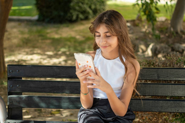 istock Beautiful girl using mobile phone to parkland 1457062016