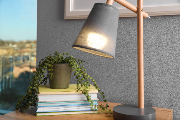 istock Books, lamp and beautiful plant on wooden table indoors. Interior elements 1457064134